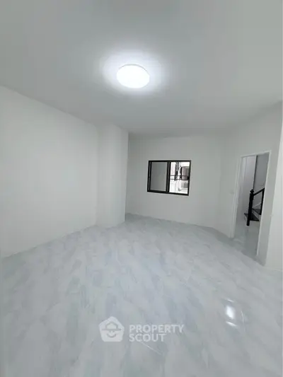 Spacious empty room with modern tile flooring and bright lighting, ideal for customization.