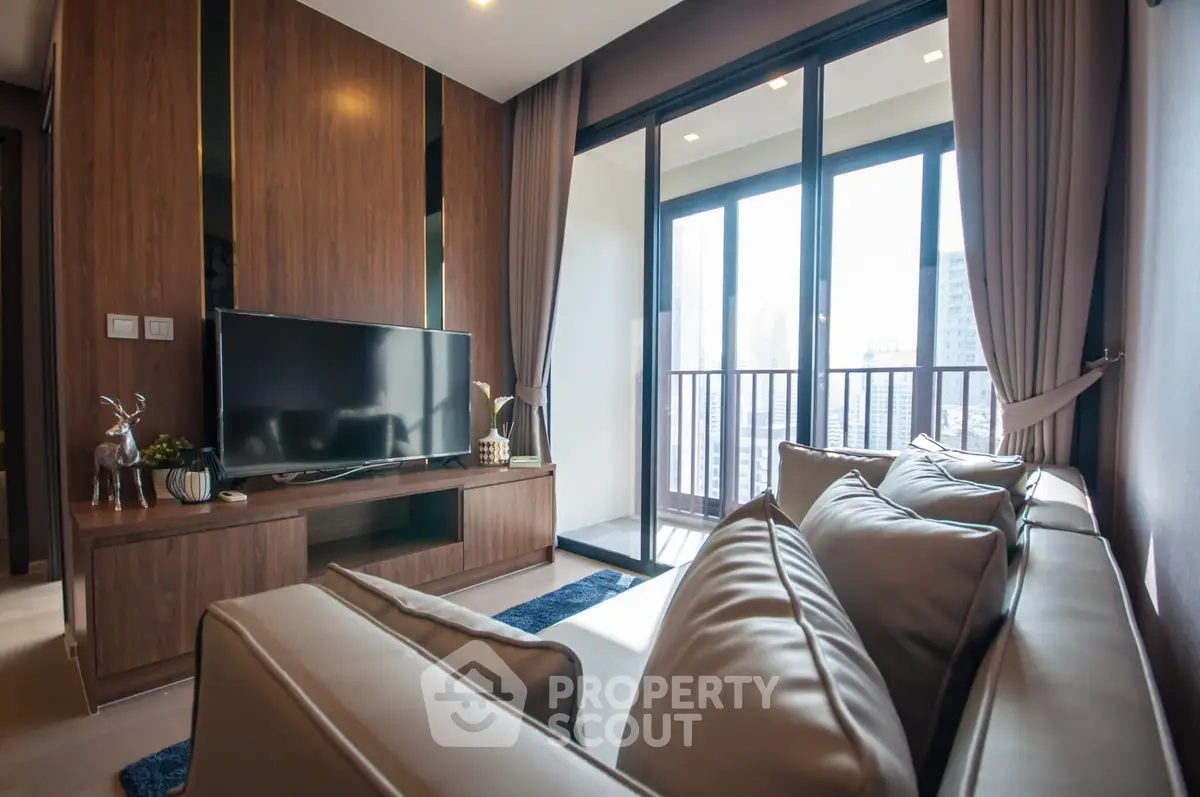 Modern living room with sleek furniture and large windows offering city views.