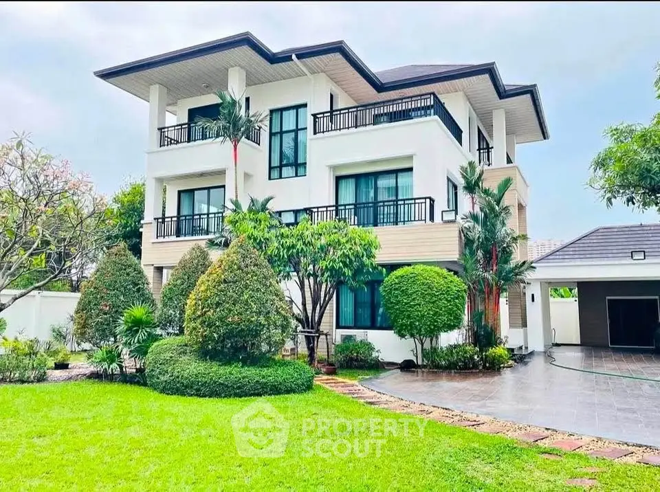 Luxurious modern villa with lush garden and spacious driveway, perfect for upscale living.