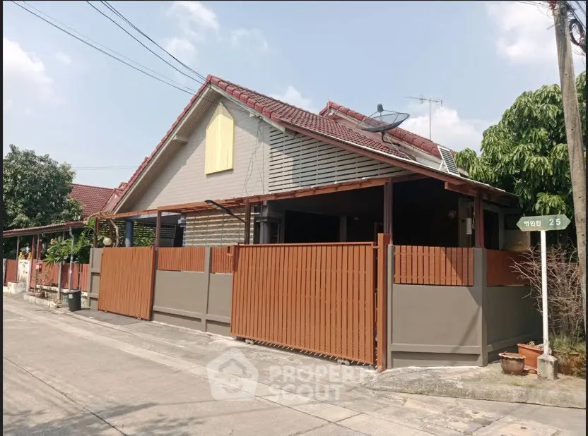 Charming suburban house with red roof and wooden fence, perfect for family living.