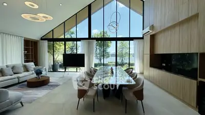 Luxurious modern living room with high ceilings, large windows, and elegant dining area overlooking a scenic view.