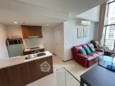 Modern open-plan living room with stylish kitchen and red leather sofa