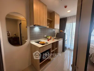 Modern kitchen with sleek wooden cabinets and built-in appliances in a cozy apartment.