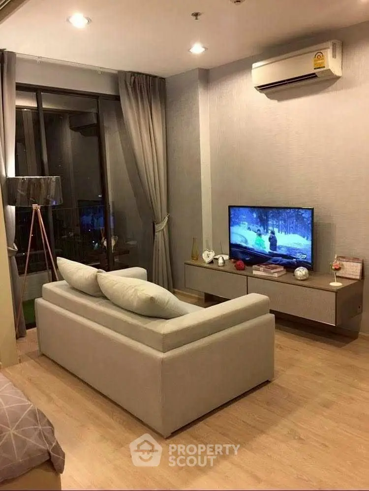 Modern living room with cozy sofa, TV, and air conditioning in stylish apartment.