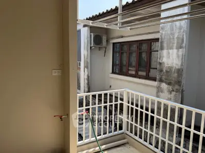 Charming balcony with utility area and outdoor view, perfect for urban living.