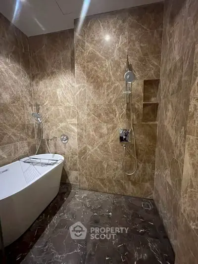 Luxurious marble bathroom with modern bathtub and dual shower setup