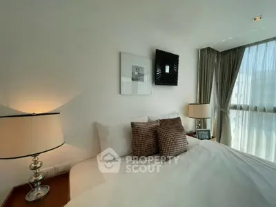 Luxurious bedroom with elegant decor and large window offering natural light