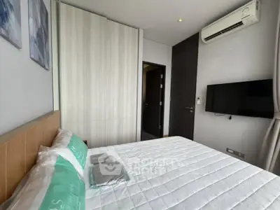 Modern bedroom with air conditioning and wall-mounted TV in a stylish apartment.