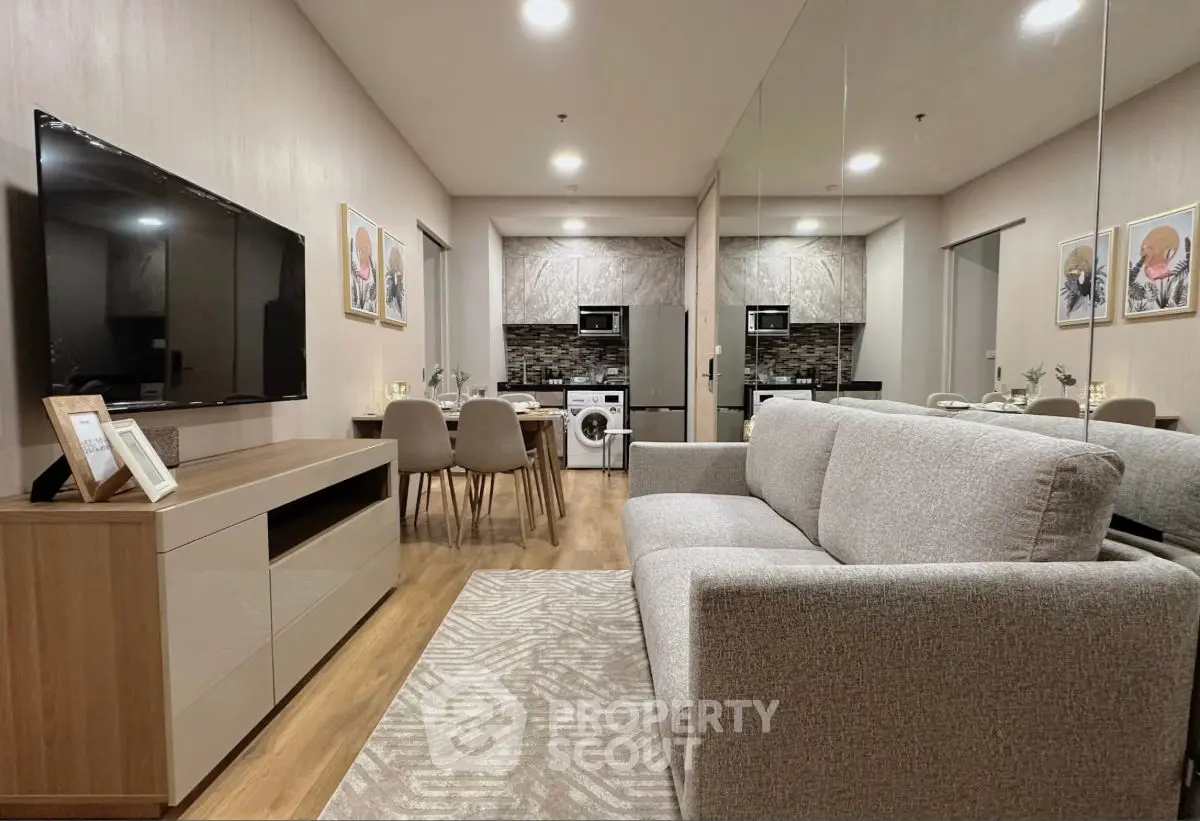 Modern living room with sleek furniture and integrated kitchen appliances in open layout.
