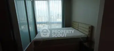 Cozy bedroom with large window offering city view and modern furnishings.