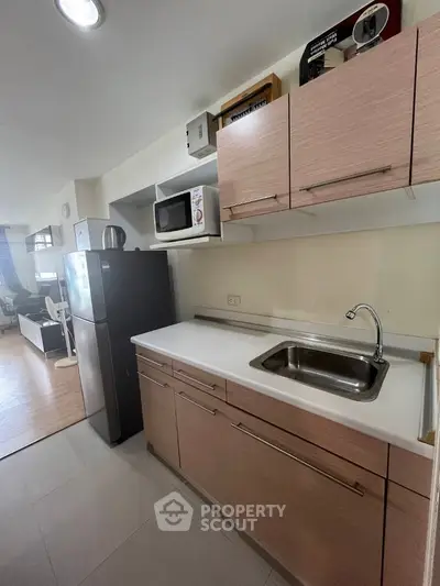 Modern kitchen with sleek cabinetry and stainless steel appliances in a stylish apartment.
