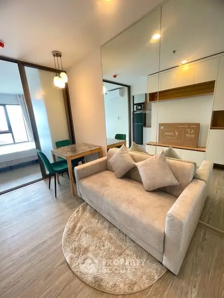 Modern living room with cozy sofa, dining area, and mirrored wall in stylish apartment.