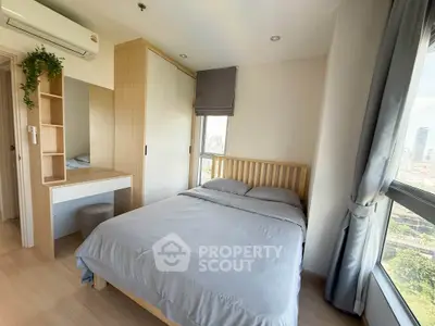 Bright and cozy bedroom with city view, featuring modern furniture and ample natural light.