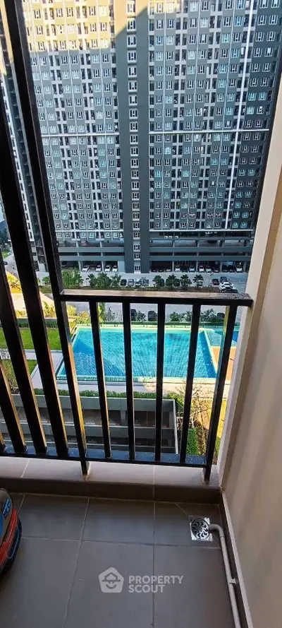 Stunning high-rise balcony view overlooking a luxurious pool and modern building facade.