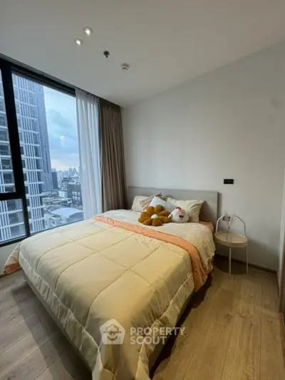 Cozy bedroom with city view, featuring a comfortable bed and modern decor.