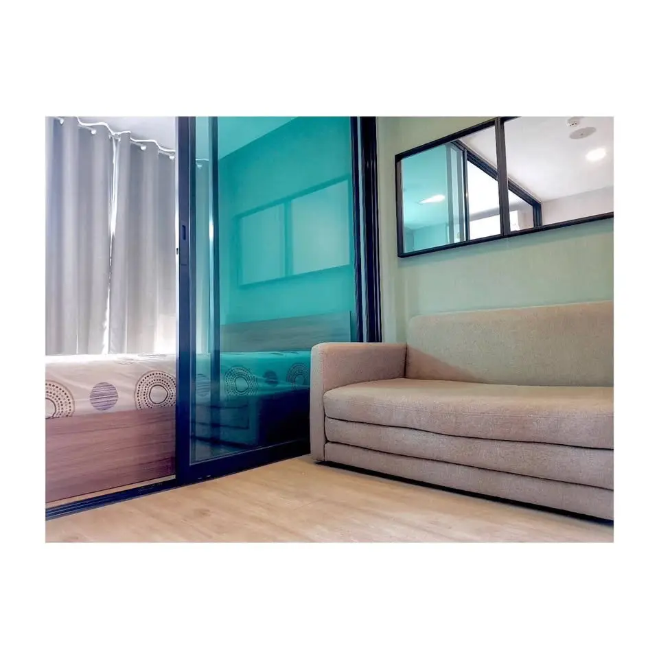 Modern living room with stylish sofa and glass partition in a cozy apartment.