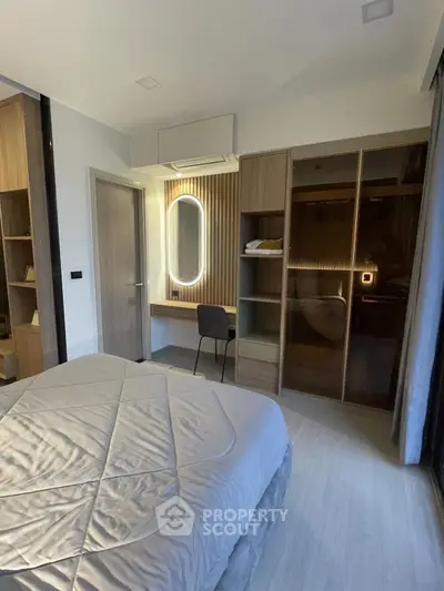 Modern bedroom with stylish decor and built-in wardrobe, featuring a cozy bed and elegant lighting.