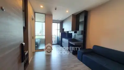 Modern open-plan living room with sleek kitchen and balcony view