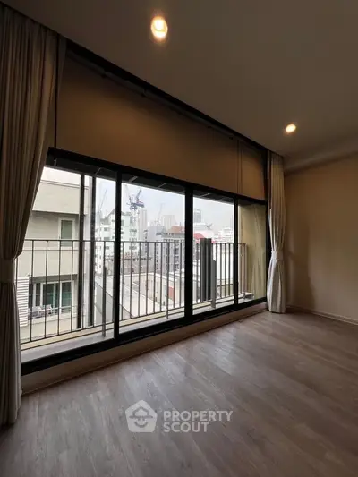 Spacious apartment with large windows offering city views and ample natural light.