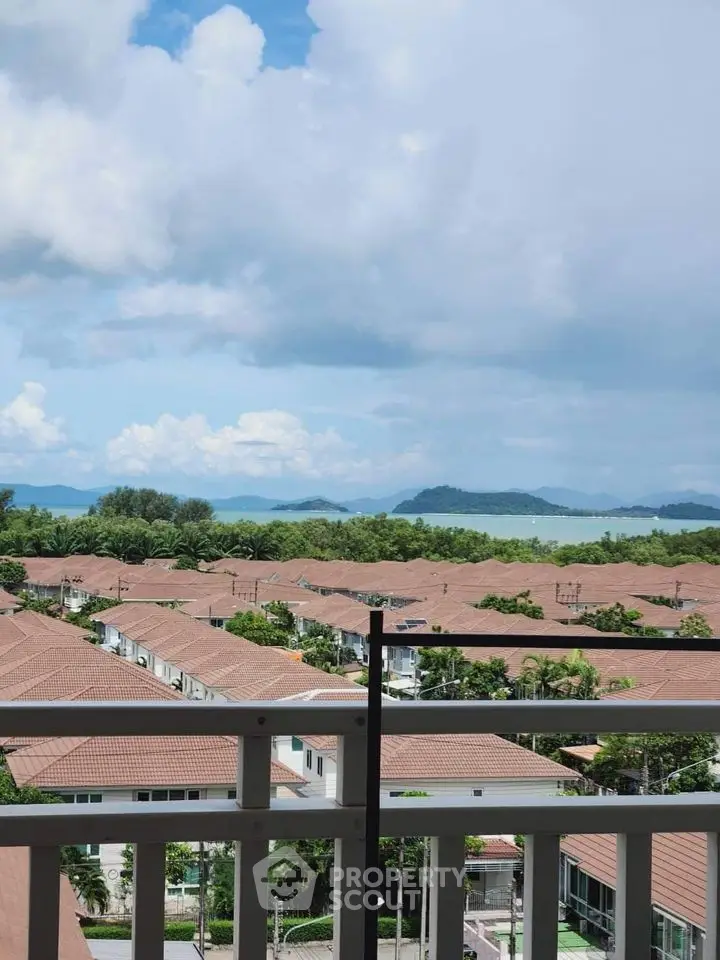 Stunning balcony view overlooking rooftops and ocean horizon, perfect for serene living.