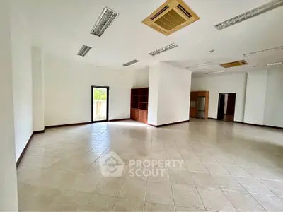 Spacious open-plan interior with tiled flooring and modern lighting, ideal for versatile use.