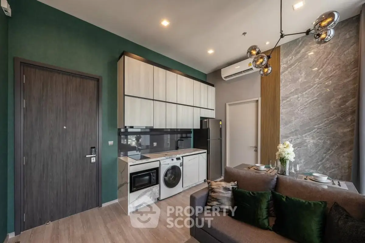 Modern living room with integrated kitchen, featuring sleek appliances and stylish decor.