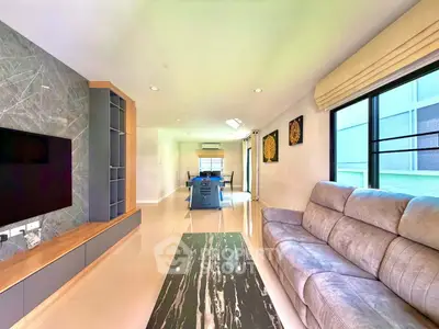 Spacious modern living room with elegant decor and open layout, featuring a cozy sofa and stylish TV unit.