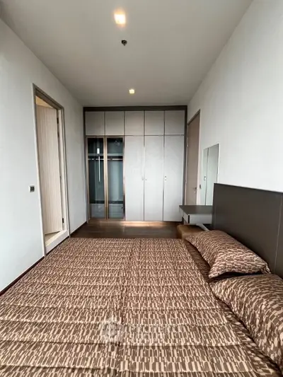 Spacious bedroom with modern design and ample closet space in a stylish apartment.
