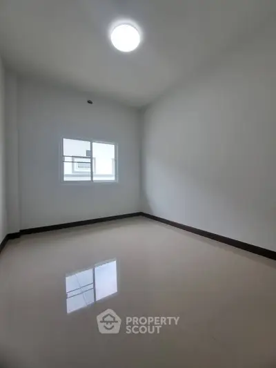Spacious empty room with large window and glossy floor, perfect for customization.