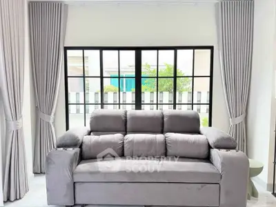 Stylish living room with plush gray sofa and large window view