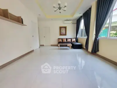 Spacious living room with modern decor and large windows for natural light