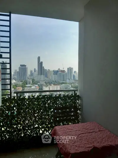 Stunning city view from a cozy balcony with table, perfect for urban living.