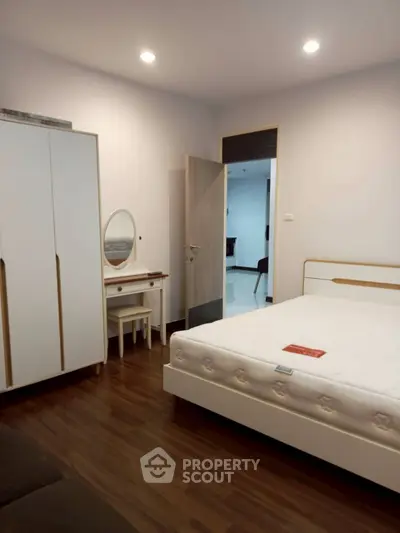 Spacious bedroom with modern furniture and wooden flooring