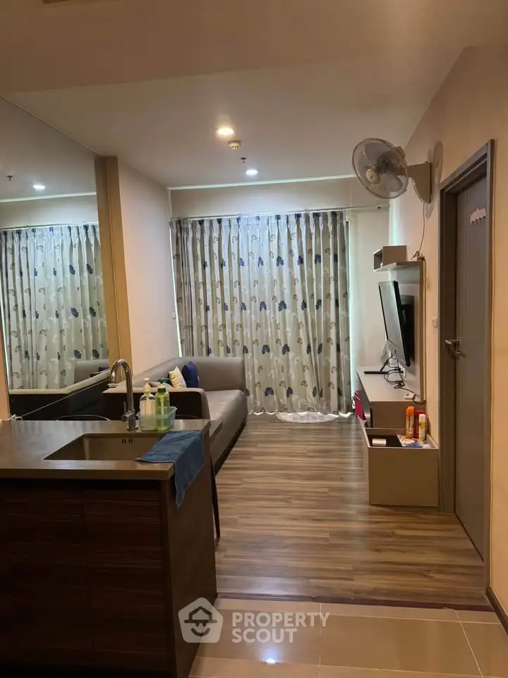 Modern living room with open kitchen, cozy sofa, and stylish decor in a contemporary apartment.