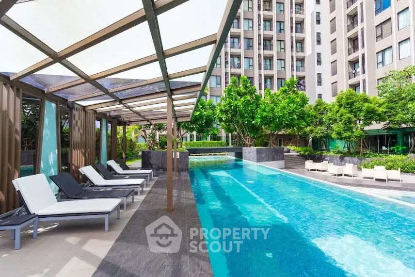 Luxurious apartment complex with stunning pool and modern lounge area.