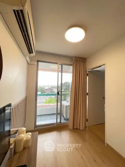 Bright living room with balcony access and air conditioning in modern apartment.