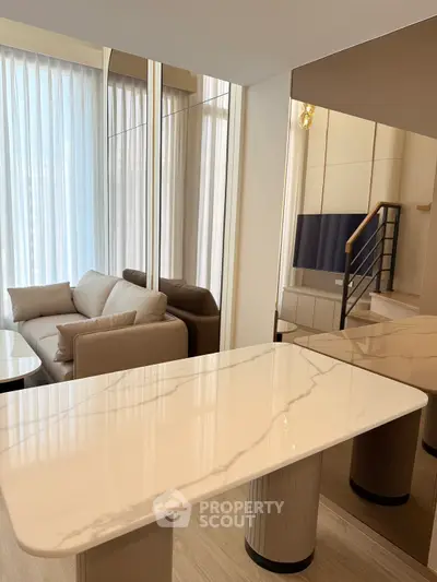 Modern living room with elegant marble table and cozy sofa, featuring floor-to-ceiling windows.