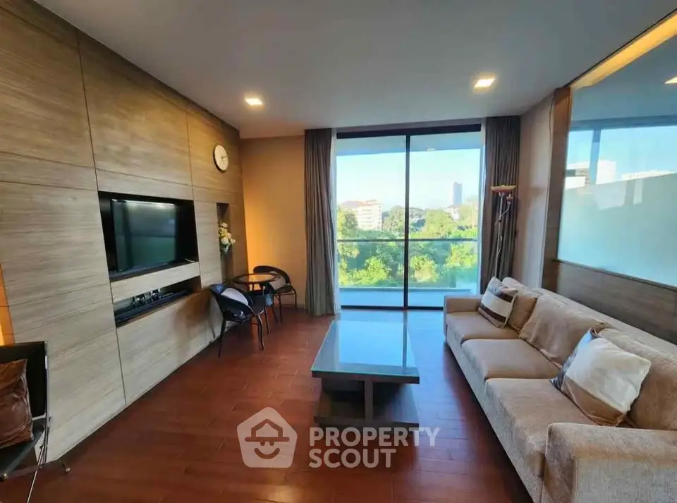 Spacious living room with modern decor and large window offering scenic view