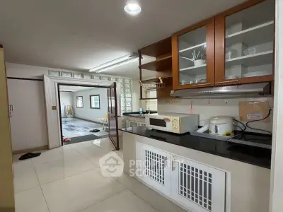 Spacious kitchen with modern appliances and open layout leading to a bright living area.