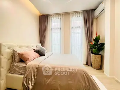 Elegant bedroom with plush bedding and natural light, featuring modern decor and air conditioning.