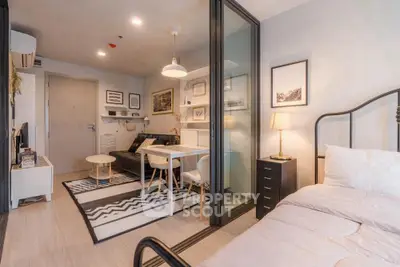 Modern studio apartment with stylish decor and open layout, featuring a cozy bed and chic living area.