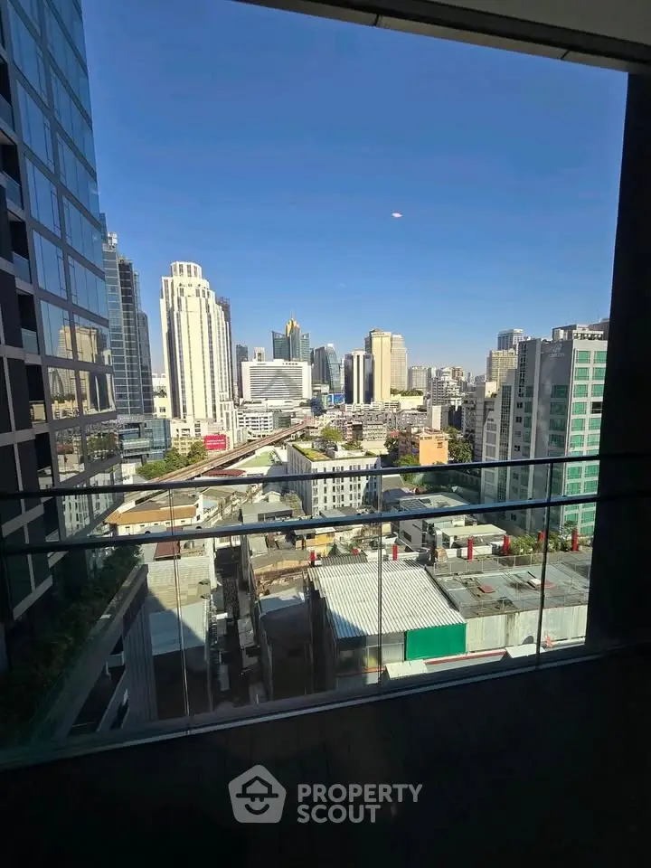 Stunning cityscape view from a modern balcony with glass railing, perfect for urban living.