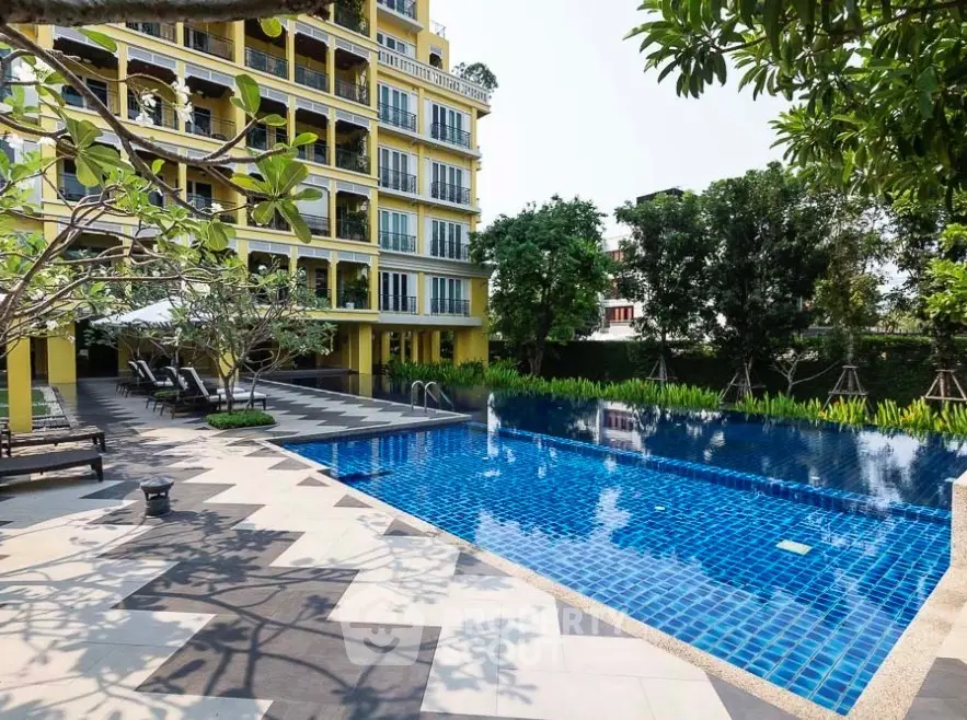 Luxurious apartment building with a stunning outdoor pool and lush greenery.