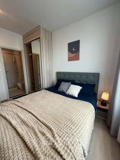 Cozy bedroom with modern decor and en-suite bathroom, featuring a plush bed and stylish lighting.