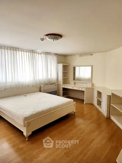 Spacious bedroom with natural light and elegant furnishings