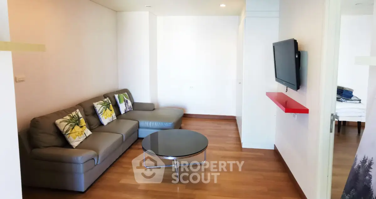 Modern living room with sleek furniture and wall-mounted TV, perfect for relaxation and entertainment.