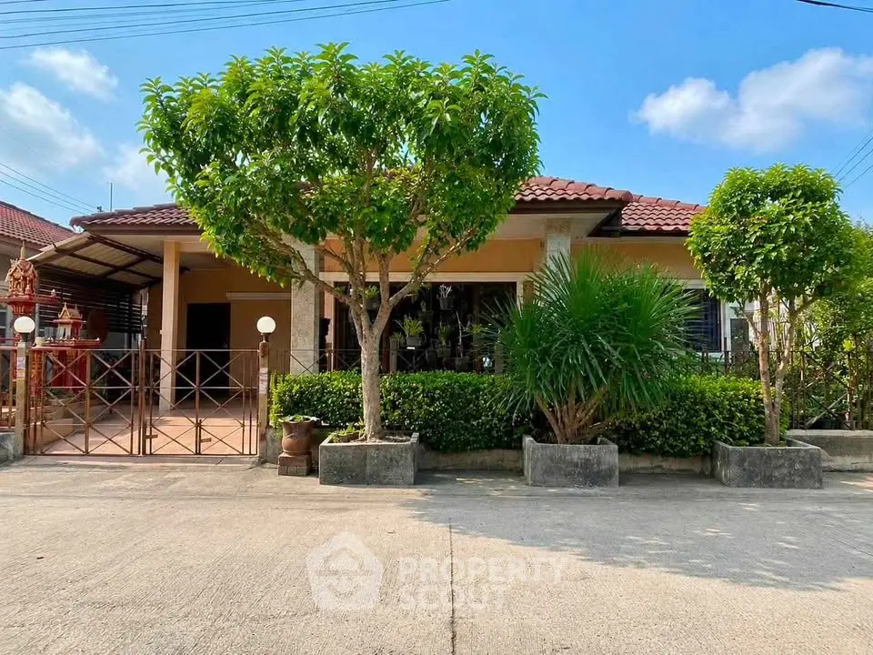 Charming single-story house with lush garden and red-tiled roof in a serene neighborhood.