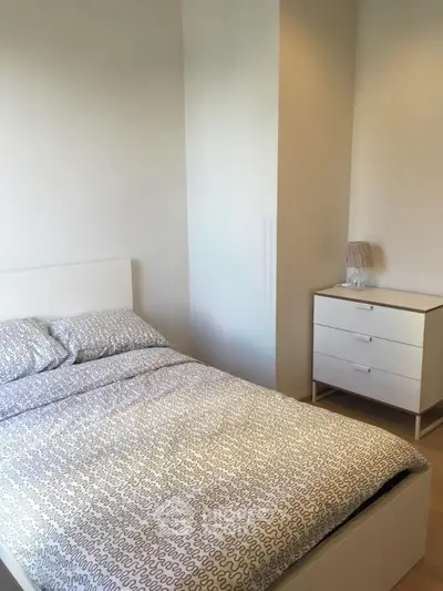 Cozy bedroom with modern white furniture and stylish bedding in a bright apartment.