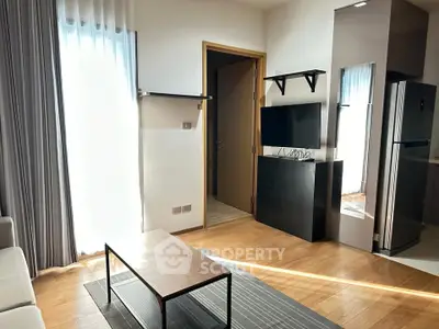 Modern living room with natural light, sleek furniture, and hardwood floors in a stylish apartment.