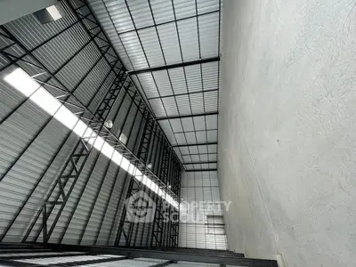 Spacious industrial warehouse with high ceilings and ample natural light.